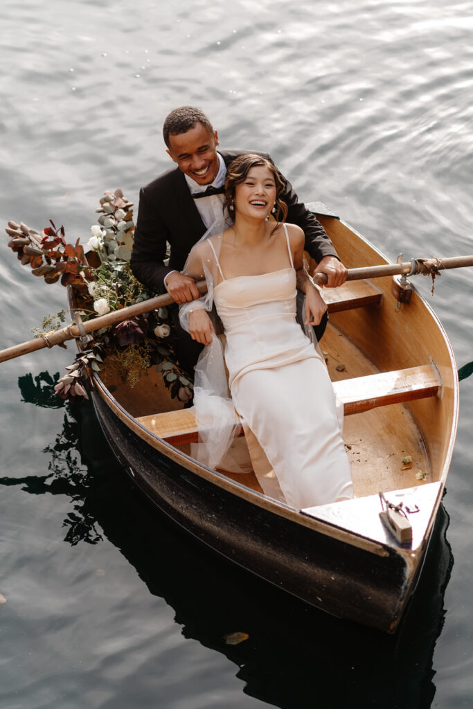 Couples Portraits on a flower filled rowing boat laughing relaxed