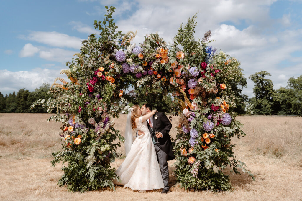 Summer marquee -Statement brightly coloured floral arch - wedding flower inspiration
